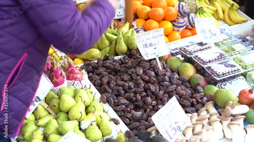 MS Vendor putting dates in paper bag in farmer's market / Norwich Market, Norfolk, United Kingdom photo