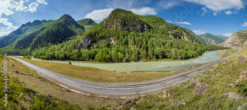 Fototapeta Naklejka Na Ścianę i Meble -  Summer panoramic view. Asphalt road passes through the gorge along the river, Chuiski tract, Altay. Travels in Russia.