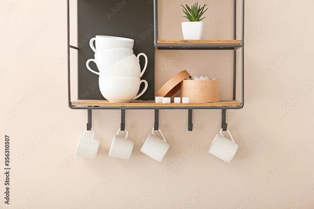 Shelf with cups on light wall Shelf with cups on light wall