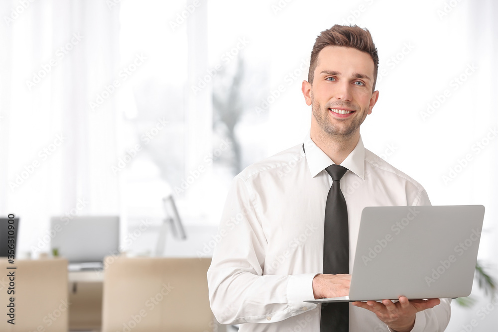 Portrait of handsome businessman with laptop in office Portrait of handsome businessman with laptop in office