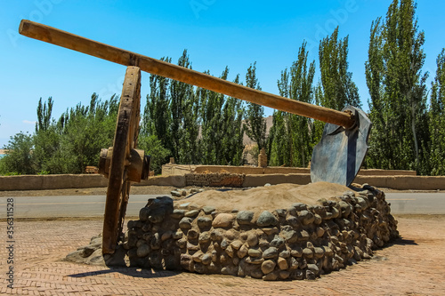 Photos A bullock cart wheel and long wooden handle hoe