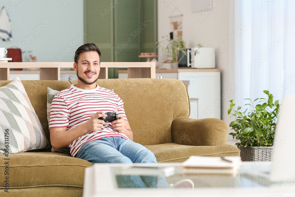 Handsome young man playing video game at home Handsome young man playing video game at home