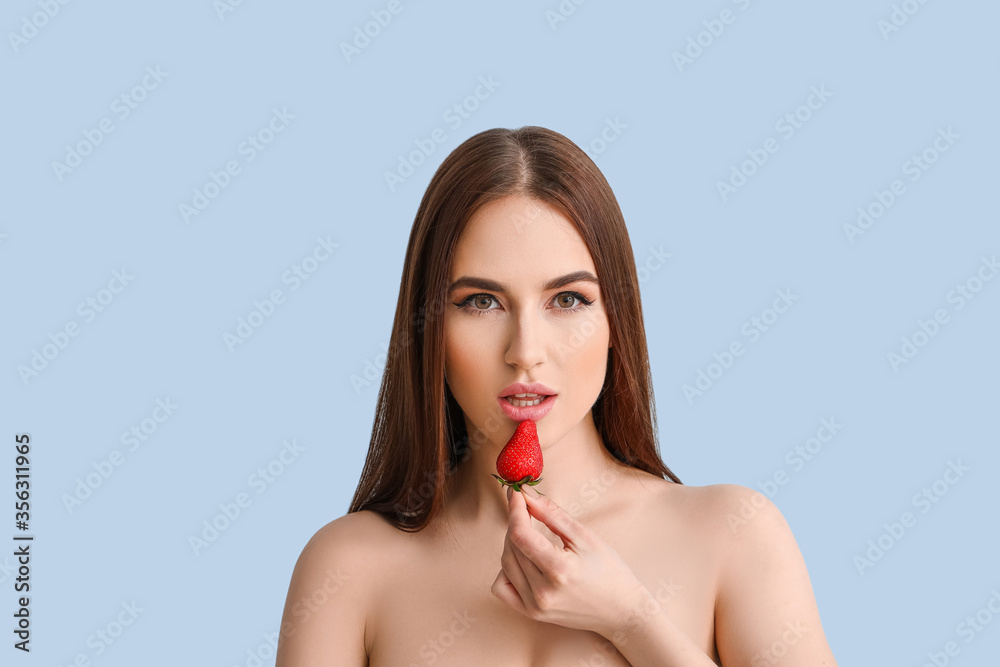 Sexy young woman with strawberry on color background Sexy young woman with strawberry on color background