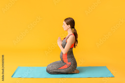 Young pregnant woman practi...