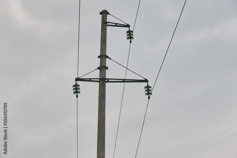 electricity transmission pole silhouetted against blue sky at dusk electricity transmission pole silhouetted against blue sky at dusk