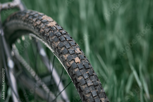 close up of checkerboard tire bike wheel covered with dirt. mountain bike wheels covered with clay. outdoor bicycle activity