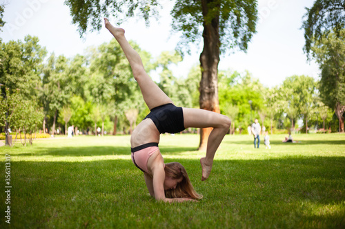 Girl is practicing yoga in the park. Healthy lifestyle. 