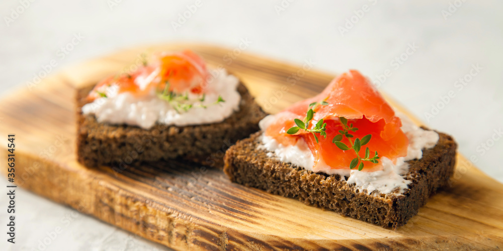 cheese, red fish and arugula sandwich on a board, selective focus, copy space cheese, red fish and arugula sandwich on a board, selective focus, copy space