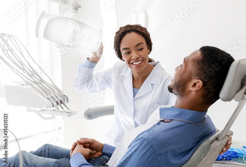 Female dentist turning on lamp before treatment