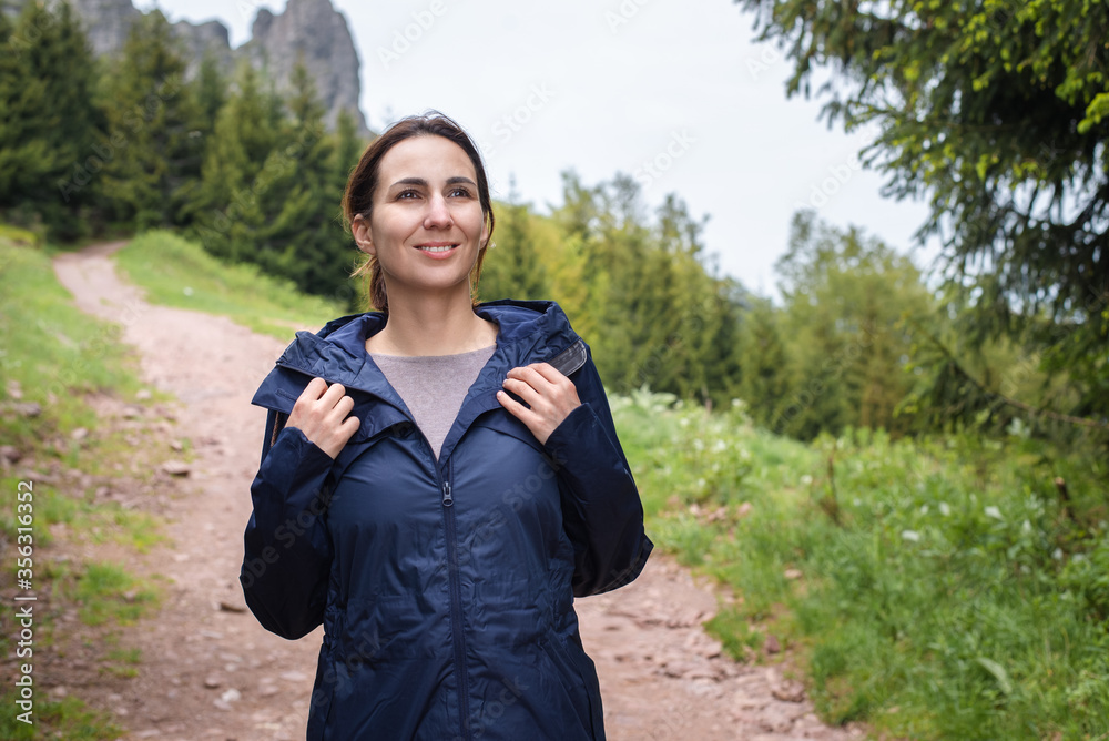 Happy adult caucasian woman hiking in mountain
