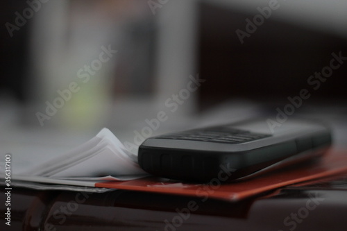 Close up of an old mobile phone and some data, papers.