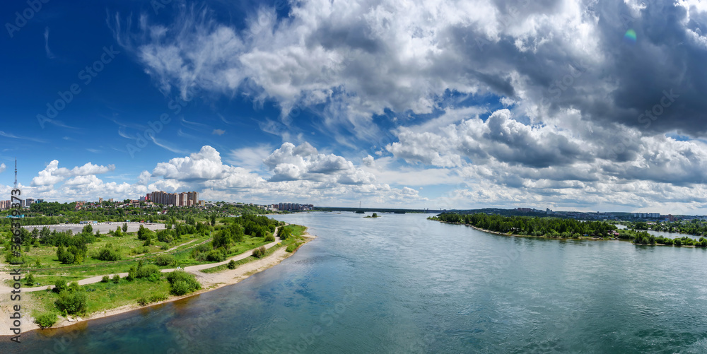 Panoramic view to Irkutsk city and the Angara river from the academic bridge in sunny summer day with beautiful clouds