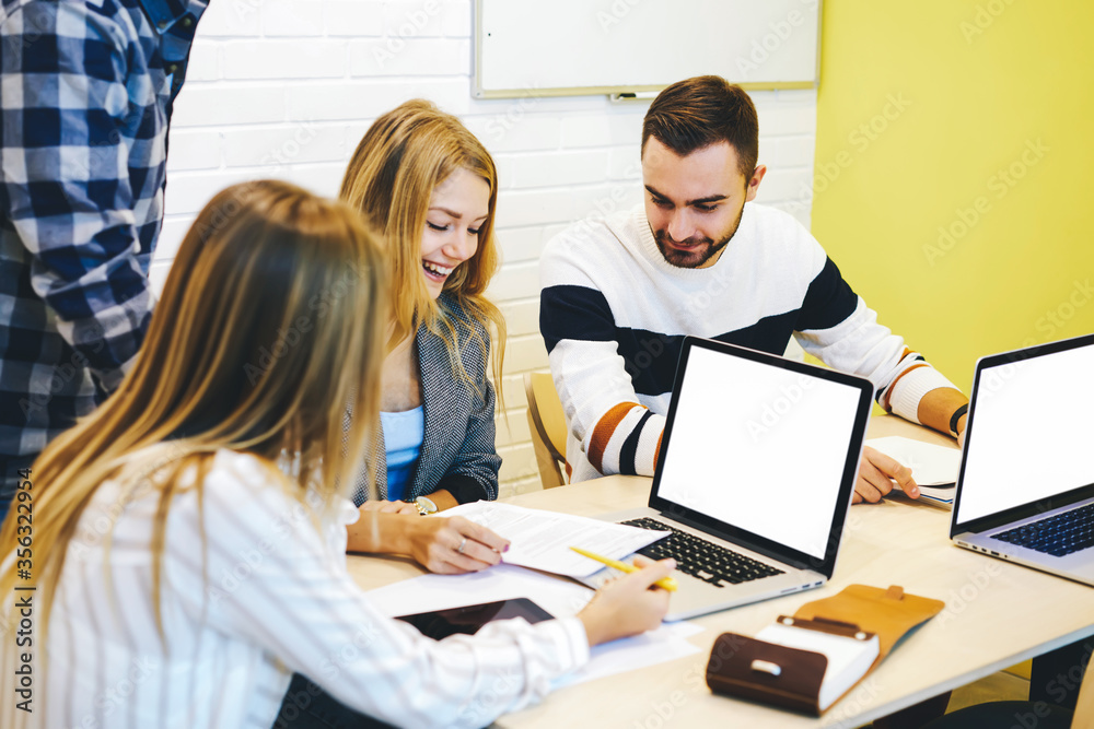 Fototapeta premium Young IT programmers collaborating on creating application using digital computers