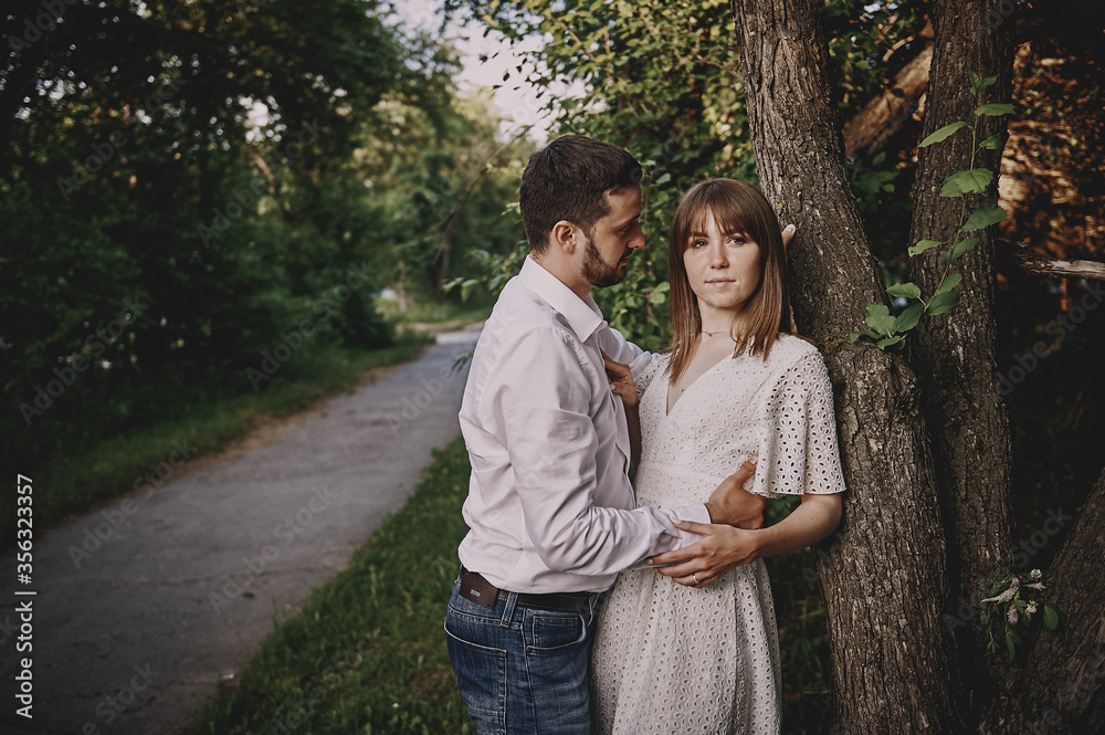 A guy and a girl are walking in the park. Romantic date evening walk. The relationship between people is love and tenderness. A guy and a girl are walking in the park. Romantic date evening walk. The relationship between people is love and tenderness.