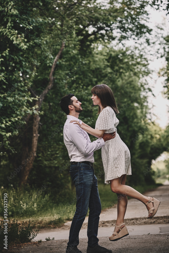 A guy and a girl are walking in the park. Romantic date evening walk. The relationship between people is love and tenderness. A guy and a girl are walking in the park. Romantic date evening walk. The relationship between people is love and tenderness.