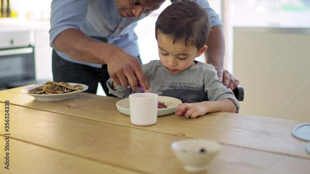 MS Father assisting son (2-3) eating pancakes with chocolate spread / Denmark MS Father assisting son (2-3) eating pancakes with chocolate spread / Denmark