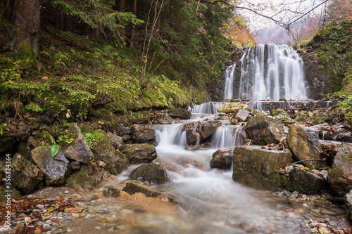 Blurred water streaming through the rocks in autumn waterfall  Slovakia