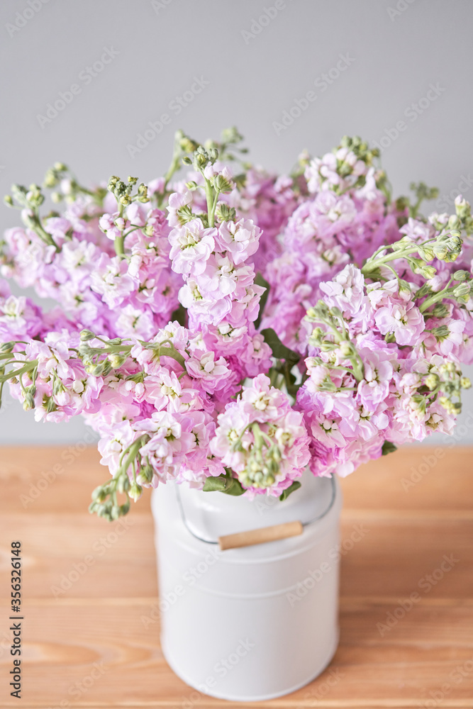 Bouquet of Beautiful lilac mattiola. Spring flowers in vase on wooden table. Flowers delivery. Bouquet of Beautiful lilac mattiola. Spring flowers in vase on wooden table. Flowers delivery.