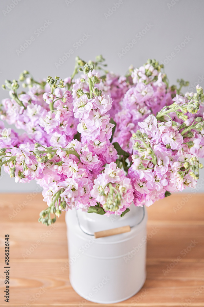 Bouquet of Beautiful lilac mattiola. Spring flowers in vase on wooden table. Flowers delivery.