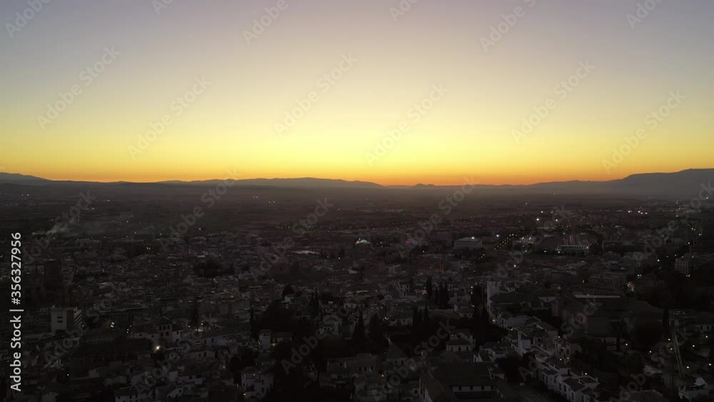 Aerial shot of cityscape against sky during sunset, drone flying backward over houses in city - Granada, Spain Aerial shot of cityscape against sky during sunset, drone flying backward over houses in city - Granada, Spain