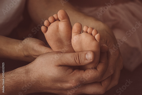 children's feet in the hands of parents