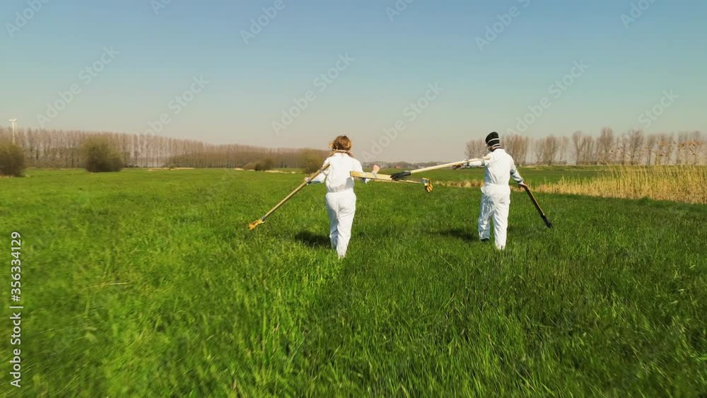 WS People wearing protective suits walking in distance in field / Prinsenbeek, Noord-Brabant, Netherlands WS People wearing protective suits walking in distance in field / Prinsenbeek, Noord-Brabant, Netherlands