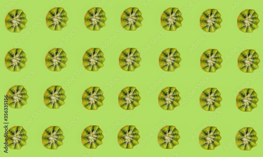 Creative color pattern of green kiwi fruit on a green background, flatlay, layout Creative color pattern of green kiwi fruit on a green background, flatlay, layout