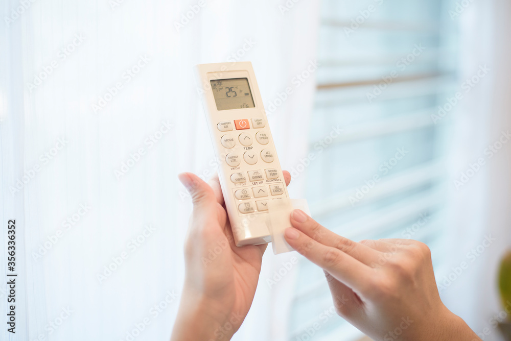 woman is cleaning remote control in house woman is cleaning remote control in house