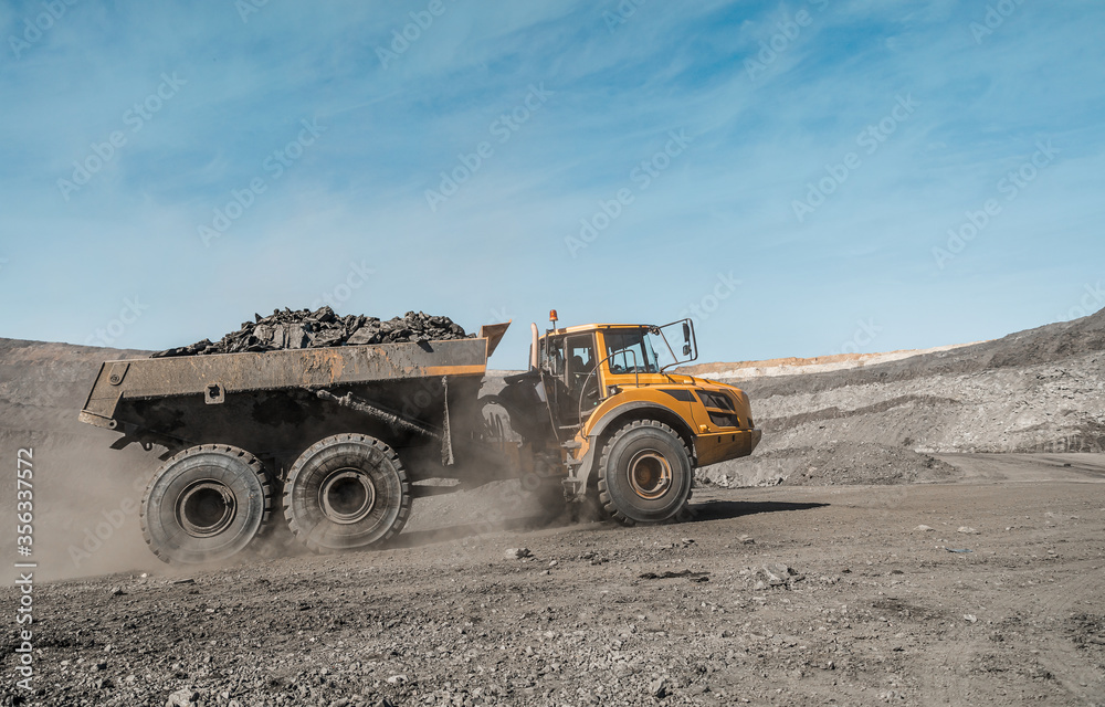 Large quarry dump truck. Loading the rock in dumper. Loading coal into body truck. Production useful minerals. Mining truck mining machinery, to transport coal from open-pit excavator work