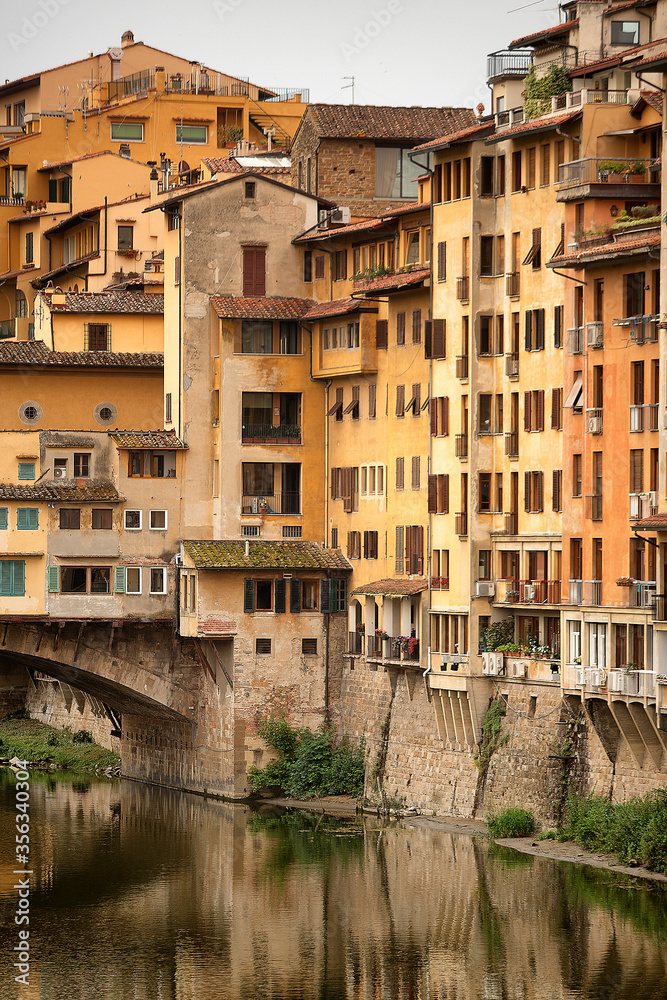 View of beautiful historic apartment buildings next to the famous Ponte Vecchio bridge