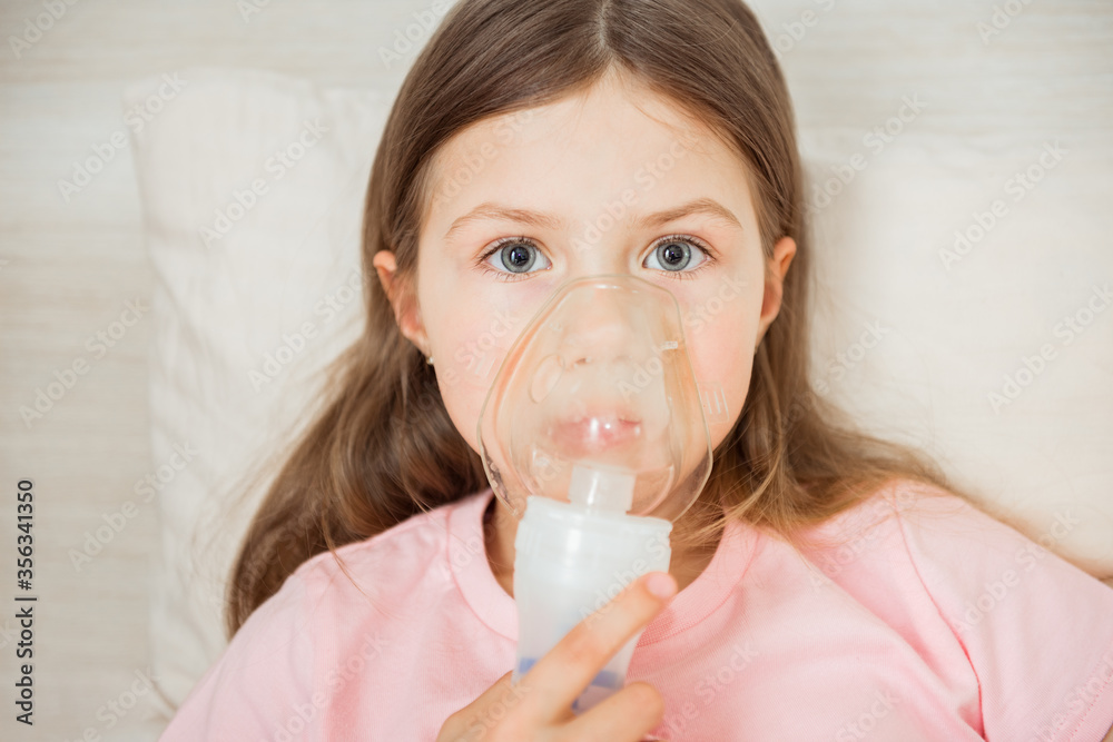 Kid with cystic fibrosis lying in a bed with Nebulizer mask Kid with cystic fibrosis lying in a bed with Nebulizer mask