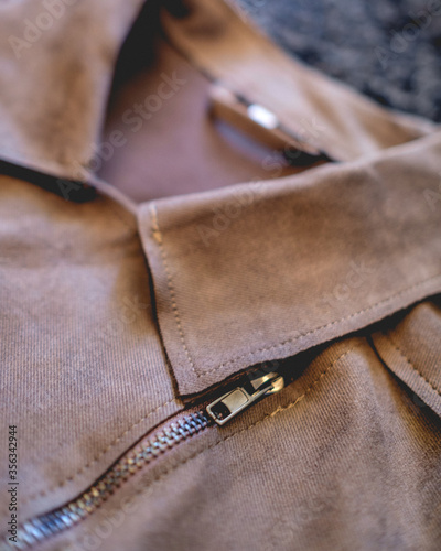 Close-up of brown eco leather jacket over black hairy background 
