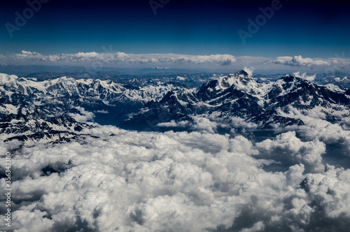 Aerial view of the Himalayas mountain ranges covered in snow and clouds © MarieXMartin