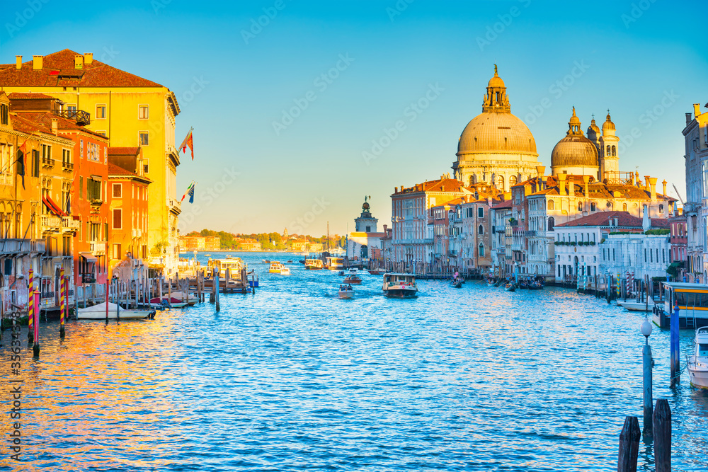 Sunset view of Grand Canal with boats and Basilica Santa Maria della Salute. Venice, Italy