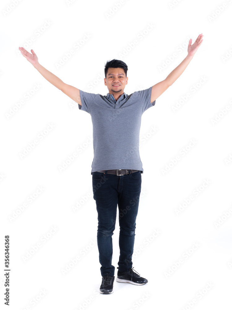 Smiling handsome Asian man in a gray polo shirt, blue jeans and athlete sports shoes who has a beard is standing and raising hands. White isolated background. Smiling handsome Asian man in a gray polo shirt, blue jeans and athlete sports shoes who has a beard is standing and raising hands. White isolated background.