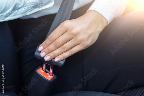 Woman belting in a car. Safety concept.