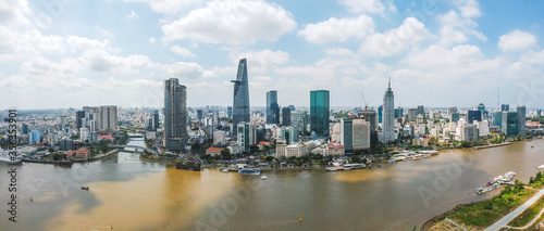 Aerial view of Bitexco Financial Tower building  train tracks  buildings  roads  and Saigon river in Ho Chi Minh city. High quality panorama image
