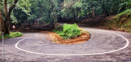 A hairpin bend road within a forest in Ponmudi, Kerala, India photo