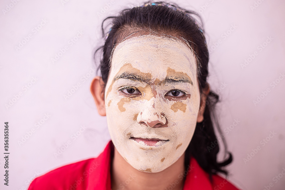 Young indin girl summer cosmetic facial mask applied over her face