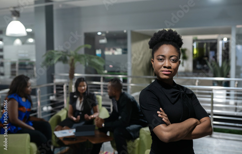 Young African businesswoman standing confidently in a modern office