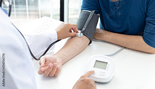 Female doctors use blood pressure monitors and stethoscope to measure pulse Diagnose the patient's disease in a modern hospital medical laboratory, Medical treatment and health care concept.