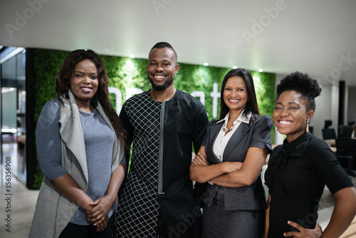 Smiling African businesspeople standing in the lobby of their office photo