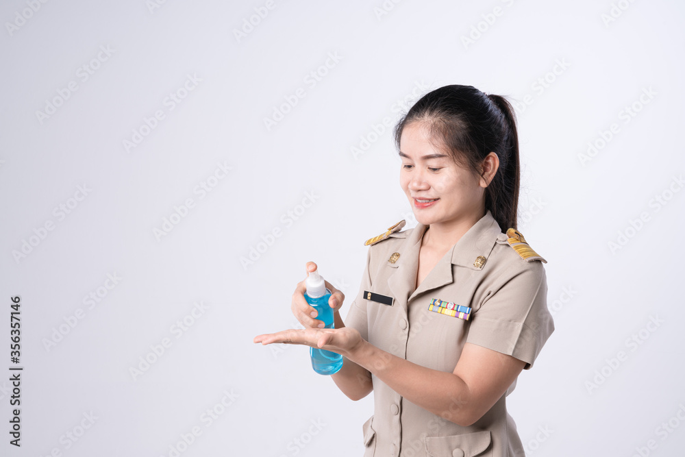 Thai teachers in official uniform pressing alcohol gel bottle for cleaning bacteria and prevent virus spreading Thai teachers in official uniform pressing alcohol gel bottle for cleaning bacteria and prevent virus spreading