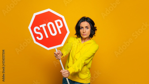 Don't u see this? Half length photo of insistent serious girl dressed in a yellow hoodie, paying attention to 