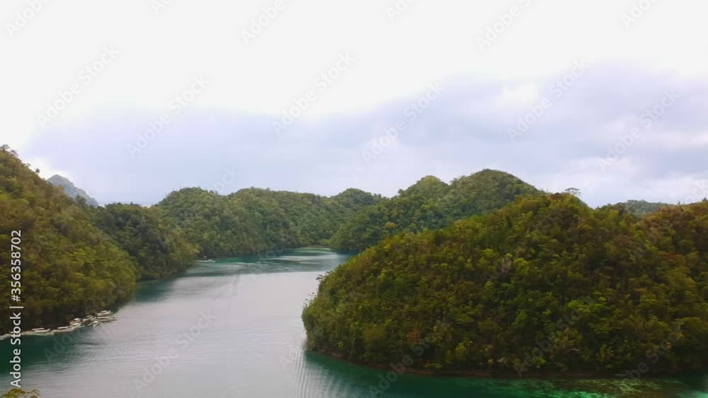Drone shot of a spectacular lagoon surrounded by epic forested hills Drone shot of a spectacular lagoon surrounded by epic forested hills