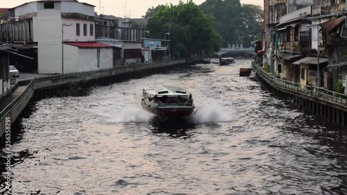 Water Bus Boat Traveling through Narrow Canals in Bangkok, Thailand photo