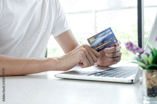 Young man people who hold credit cards and use laptops for online shopping and making payments Internet
