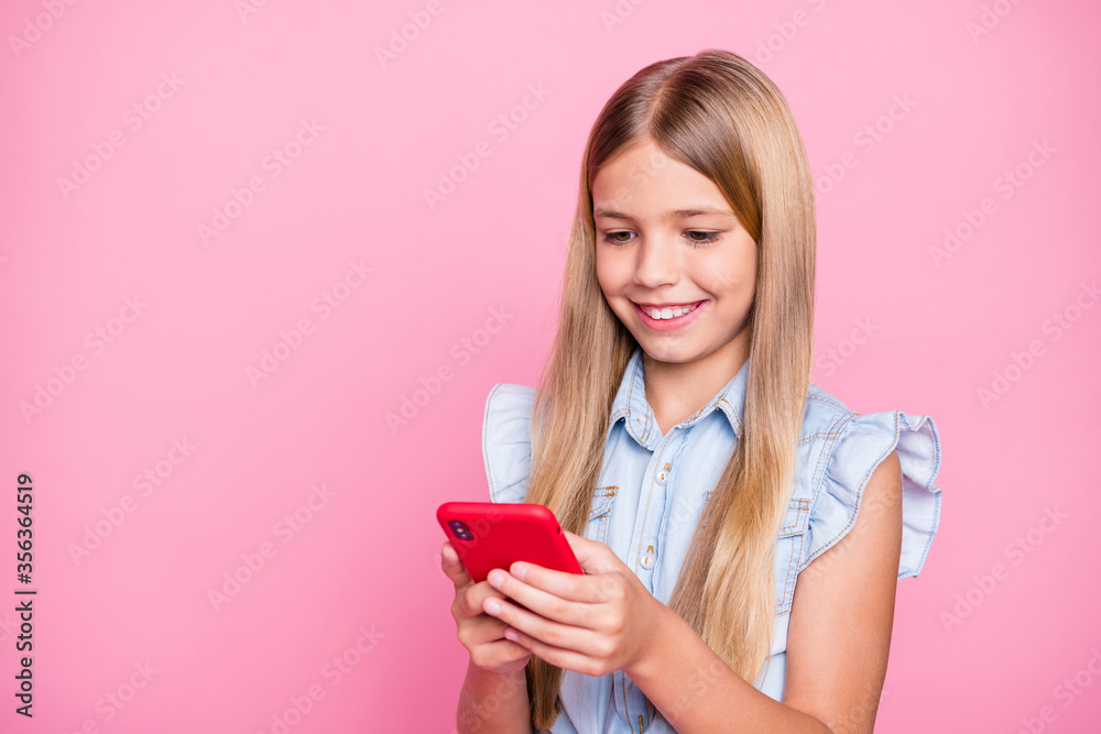 Portrait of positive blogger kid girl use smart phone enjoy social media news subscribe comment repost wear denim jeans shirt isolated over pastel color background Portrait of positive blogger kid girl use smart phone enjoy social media news subscribe comment repost wear denim jeans shirt isolated over pastel color background