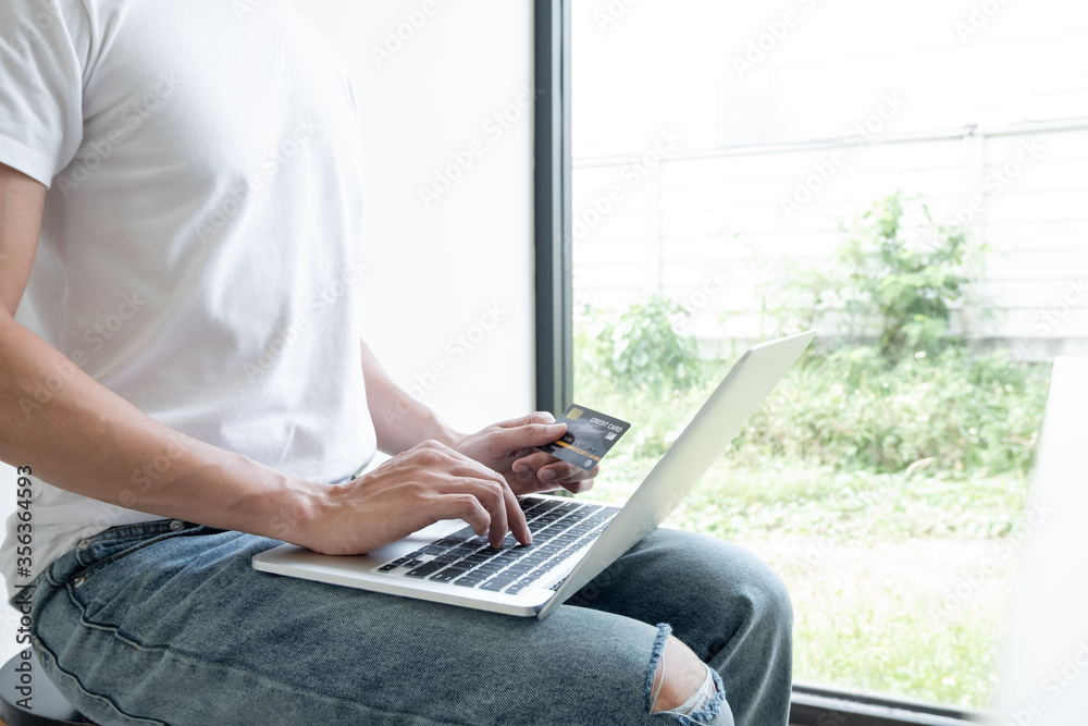 Naklejka premium Young man people who hold credit cards and use laptops for online shopping and making payments Internet