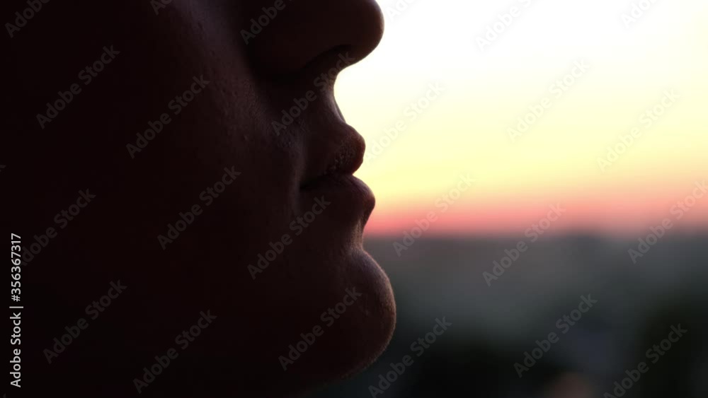 Silhouette of a man eating the sun as a joke on a sunset background Silhouette of a man eating the sun as a joke on a sunset background